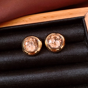 Detail of 18K gold-plated oval stud earrings with champagne gems in a velvet box