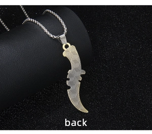 Detailed back view of a punk scythe pendant showing golden edges and geometric textures