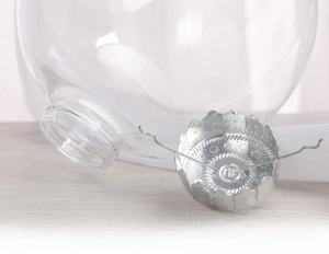 Macro shot of clear plastic Christmas ball with a secure silver metal cap and wire spring