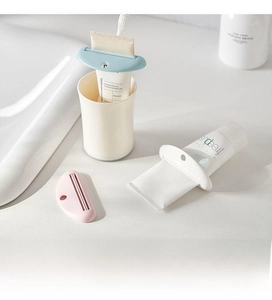 Close-up of manual tube squeezer showing half-moon design and slot for toothpaste