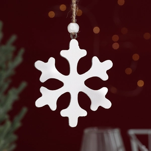 White wooden snowflake ornament with jute twine and wooden bead on festive red background