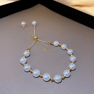 Close-up of pearl bracelet with gold beads and adjustable slider clasp on tray
