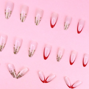 Almond shaped nude press-on nails with gold foil accents and red French tip design