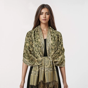 Detailed view of green paisley cashmere scarf with intricate floral patterns and tassels