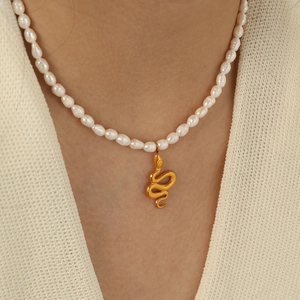Retro stainless steel necklace with fresh water pearls and gold snake pendant on model