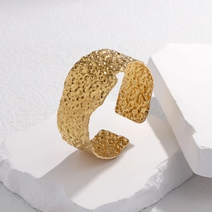 Detailed close-up of 18K gold plated wide cuff bangle featuring irregular hammered textures