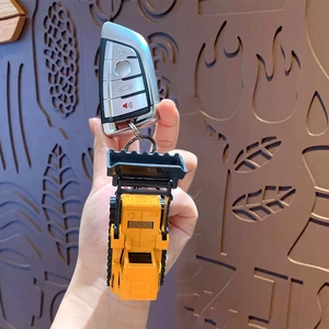 Mini yellow excavator toy keychain attached to car key, creative alloy truck pendant