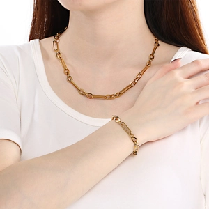 Gold stainless steel square link chain necklace and bracelet set worn by a model