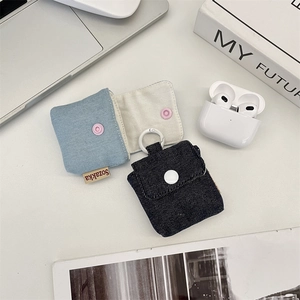 Detailed view of denim fabric headphone cases with snap button and woven label detail