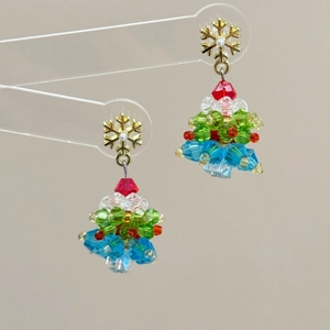 Macro shot of handmade beaded Christmas tree earrings with colorful crystal beads and gold stud