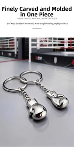 Detailed view of silver zinc alloy 3D boxing glove keychains on a boxing ring surface