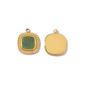 Macro shot of gold square pendant featuring a green gemstone and a smooth metal back