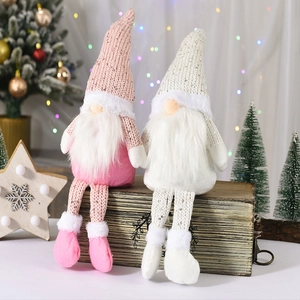 Nordische Weihnachts-Wichtel mit Paillettenhüten und langen Beinen auf einer Holzkiste