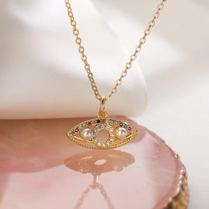 Gold plated evil eye necklace with colorful zircon and white pearls on pink agate