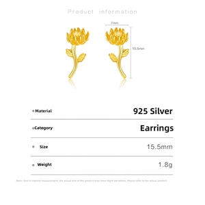 Macro shot of 925 sterling silver daisy earrings with gold finish and green leaf details