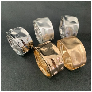 Detail of wide metal bangles with irregular hammered texture in silver and gold finishes