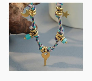 Macro detail of hand-woven bohemian necklace with moon star and key gold plated pendants