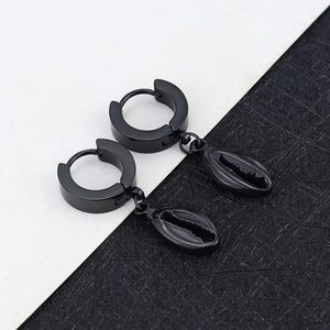 Detail of black conch shell pendants hanging from polished hoop earrings in dark finish