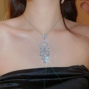 Gros plan du collier attrape-rêves scintillant avec strass clairs porté par un mannequin
