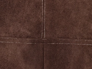 Makroaufnahme von dunkelbraunem Wildleder mit weißer Kontrastnaht und Ledertextur-Detail