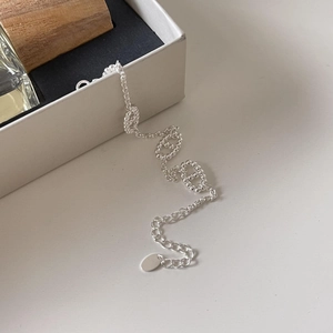 Detailed macro view of S925 sterling silver beaded chain with extension and oval tag