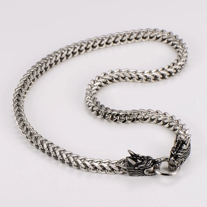 Macro detail of men's stainless steel dragon head clasp on heavy woven chain