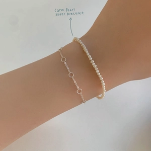 Minimalist S925 sterling silver layered bracelet with small pearls on model wrist