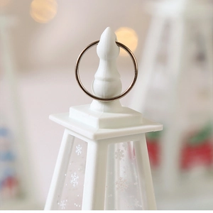 Close-up of white Christmas lantern top with metal hanging ring and snowflake pattern
