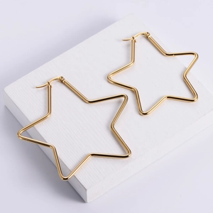 Polierte goldene Creolen in Sternform mit minimalistischem Design auf weißem Ständer