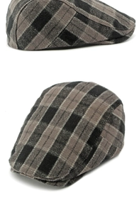 Detailed close-up of the grey plaid wool texture and short brim of the vintage flat cap