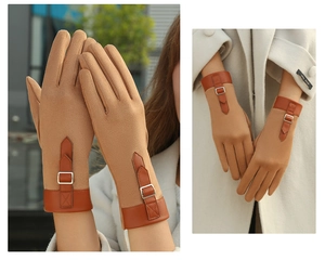 Detail of light brown suede gloves featuring leather strap buckle and touch screen design