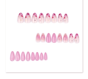 Detail of pink almond press-on nails with heart patterns and rhinestone embellishments