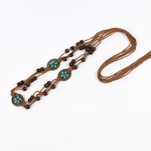 Detail of bohemian handmade waist chain with dark wood beads and blue rhinestone charms