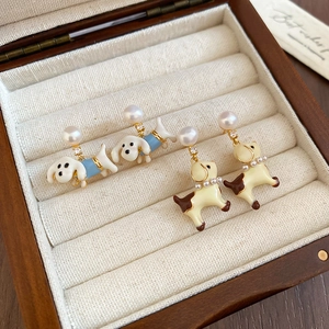 Detail of cute enamel puppy earrings with pearls and crystals in a vintage jewelry box