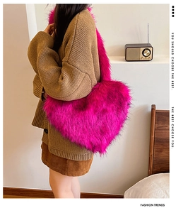 Detailed view of large heart-shaped rose red faux fur tote bag worn by a model