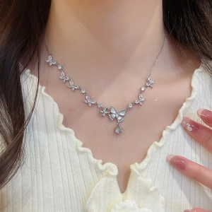 Detail of silver butterfly pendant necklace with zircon stones on model collarbone
