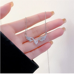 Macro view of crystal angel wing heart pendant with micro-paved cubic zirconia