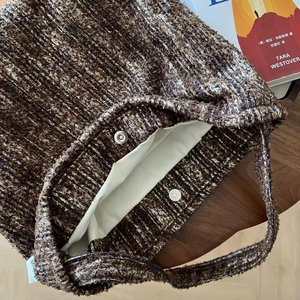 Close-up of retro tweed shoulder bag showing inner lining and silver magnetic buckle