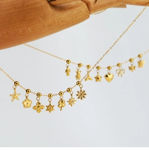 Detailed view of a golden stainless steel necklace with tiny flower and star charms