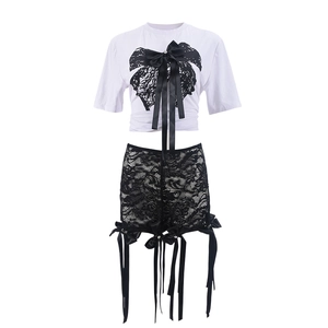Détail du t-shirt blanc imprimé papillon et de la jupe noire en dentelle