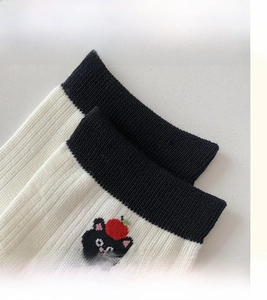 Macro shot of high-elastic black ribbed cuff with cat embroidery on cotton socks