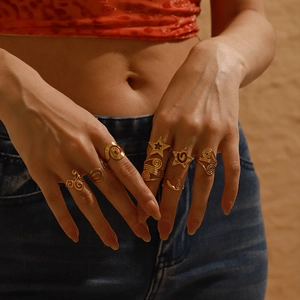 Close-up of bohemian gold-plated ring set with star and wave patterns on model