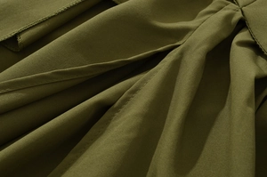 Detailaufnahme von armeegrünem Twill-Stoff mit feinen Doppelnähten und Texturdetails