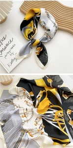Detail of silk scarf with yellow and black geometric patterns and golden chain print
