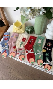 Flat lay of colorful mink velvet socks with fruit patterns and cute bow details