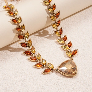 Detailed macro view of vintage gold necklace with marquise gems and large teardrop pendant