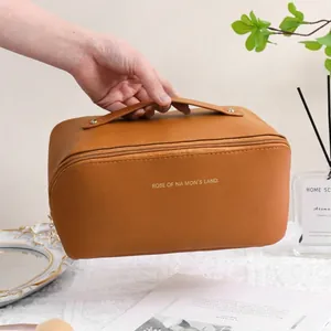 Minimalist brown PU leather cosmetic bag with top handle and gold zipper closure