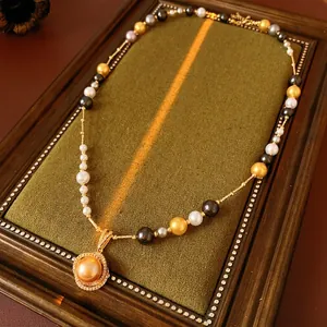 Luxurious multi-color pearl necklace with a large gold pearl pendant in a vintage frame