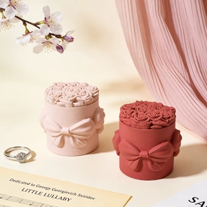 Dettaglio di portagioie in resina con rose a rilievo e un grande fiocco decorativo