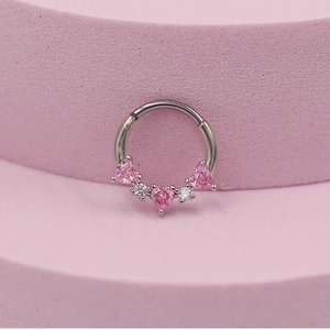 Detail of silver nose ring with pink heart gems and white stones on pink display stand
